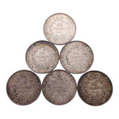 six pièces d'argent disposées en pyramide sur un fond blanc
