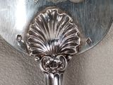a silver fan with a dragon on it on a table