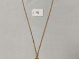 un collier en or orné d'une croix et d'une plaque