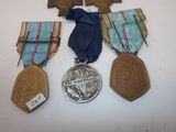 several medals are displayed on a white surface with a blue ribbon