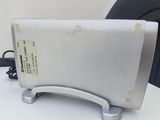 a silver toaster sitting on a table with a black chair in the background