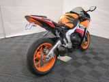 an orange and black motorcycle parked in a garage