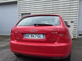 une voiture rouge garée devant un bâtiment