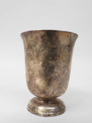 a silver vase that is sitting on a white surface