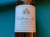 une bouteille de vin posée à côté d'un cigare sur une table de billard