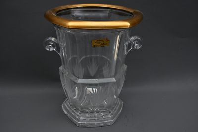 vase en verre transparent avec un bord et des anses dorés sur un fond gris