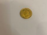 a close up of a gold coin on a white surface