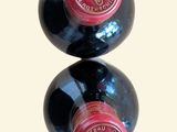 two bottles of wine sitting on top of each other