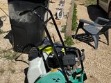 a lawn mower sitting on the ground next to a trash can