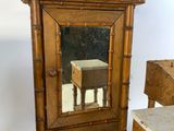 a small wooden cabinet with a mirror on it