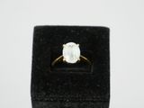 an engagement ring with a white diamond in a black velvet box