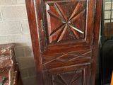 a tall wooden cabinet with a clock on top of it