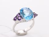 a close up of a ring with a blue topaz and purple amethtites