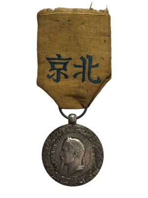 une vieille médaille sur laquelle figure une inscription en chinois au recto