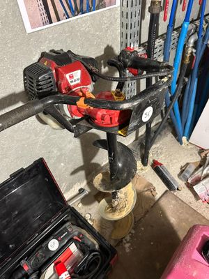 a picture of a drill in a garage with tools on the floor