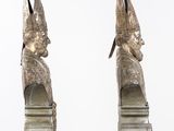 pair of silver colored sculptures of a man and a woman