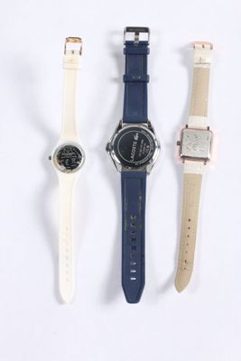 three watches are lined up in a row on a white surface