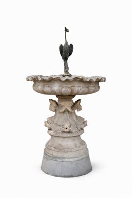 un oiseau perché au sommet d'une fontaine, sur fond blanc