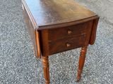 an old wooden table with a drawer on top of it
