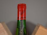 a bottle of wine sitting on top of a wooden block