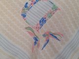 a table with a white table cloth with a picture of two birds on it