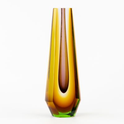 un vase marron et vert posé sur une surface blanche