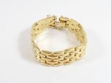 gros plan d'un bracelet en or sur une surface blanche