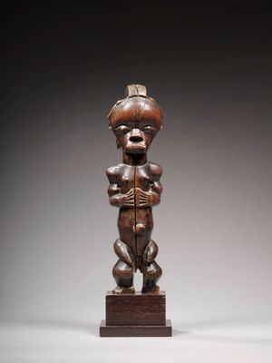 une image d'une statue en bois représentant un homme tenant un bébé