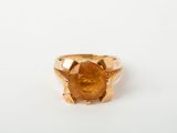 Gros plan sur une bague contenant une pierre orange