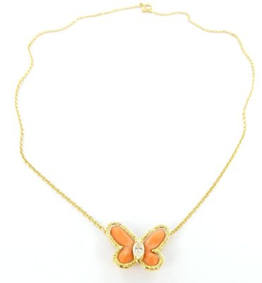 un collier représentant un papillon orange avec une chaîne dorée sur fond blanc