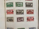 an open book with a bunch of stamps on it sitting on a table
