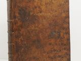 an old book with a brown cover sitting on top of a table