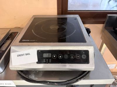une plaque de cuisson argentée surmontée d'un brûleur noir