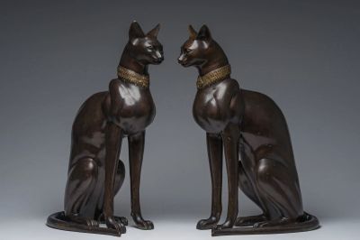 two bronze statues of a cat and a dog sitting next to each other