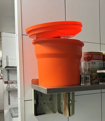 un pot orange posé sur une étagère dans une cuisine