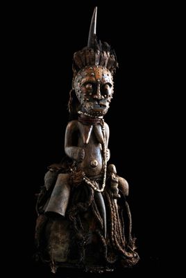 un gros plan sur la statue d'une personne assise sur un rocher