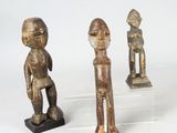 three wooden figurines of a man and a woman on acrylic bases