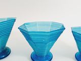 three blue glass vases sitting on top of a white surface