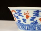a blue and white bowl with a gold fish design on it