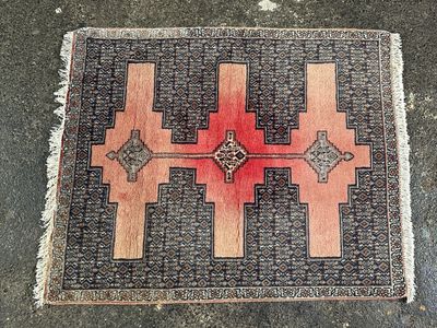 un tapis rouge et noir posé sur un sol en béton