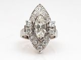 une bague en or blanc sertie d'un diamant de taille marquis entouré de diamants taille baguette