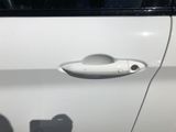a white car with a door handle on it ' s side