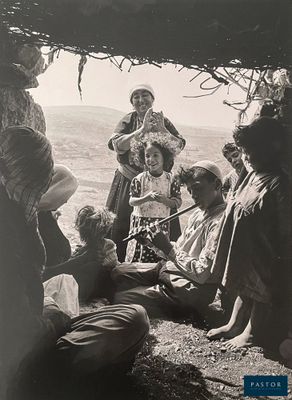 black and white photograph of a group of people sitting under a tree