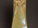 a green vase sitting on top of a wooden table