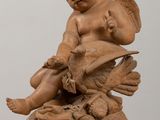 a small statue of a boy sitting on a bird