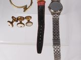 two watches and a ring on a clear display case