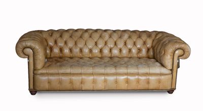 Canapé Chesterfield en cuir marron sur fond blanc, avec une zone de découpe pour le texte
