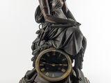 statue en bronze représentant une femme assise au sommet d'une horloge