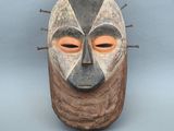 une image représentant un masque en bois d'où jaillissent des pointes