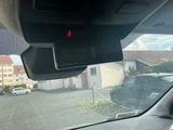 une voiture qui roule dans la rue et qui porte une croix rouge